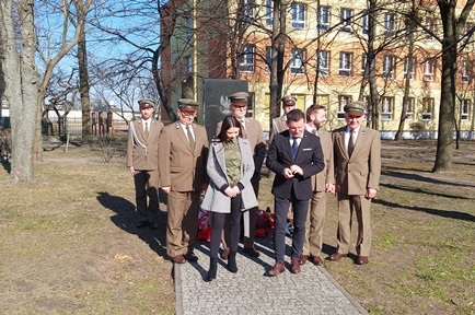 Zdjęcie przedstawia delegację przy pomniku
